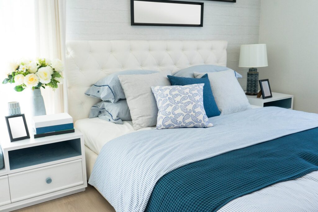 Łóżko z niebieskimi poduszkami