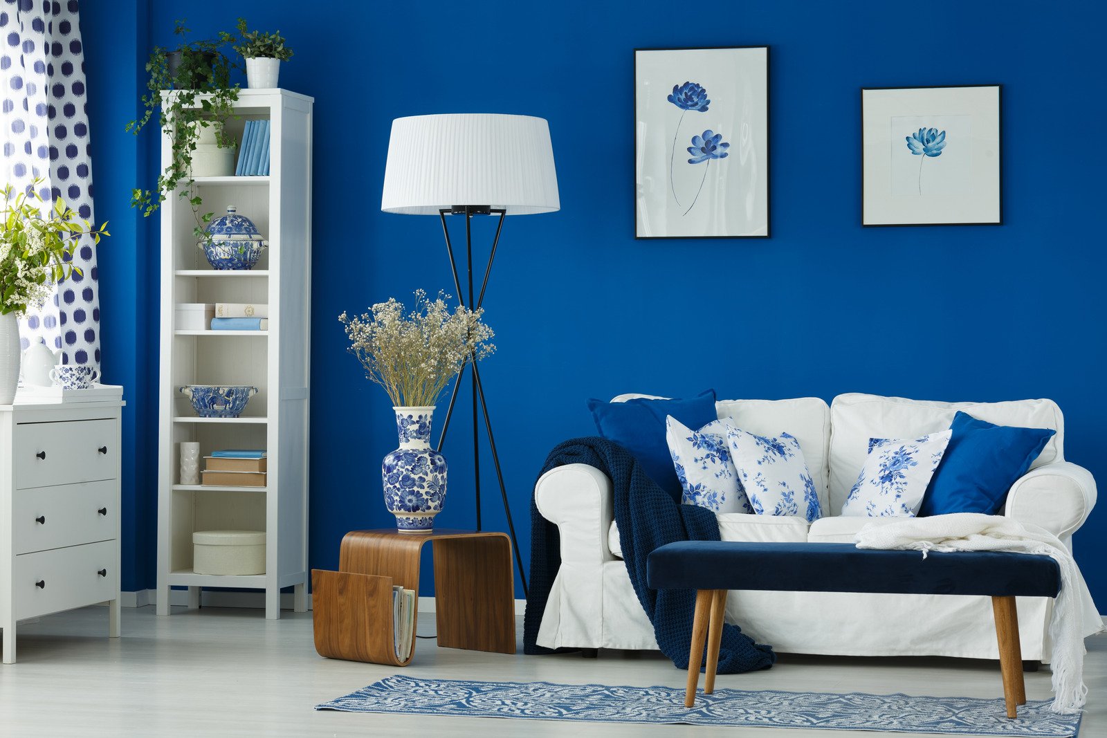 błękitna tapeta i biała sztukateria na ścianie