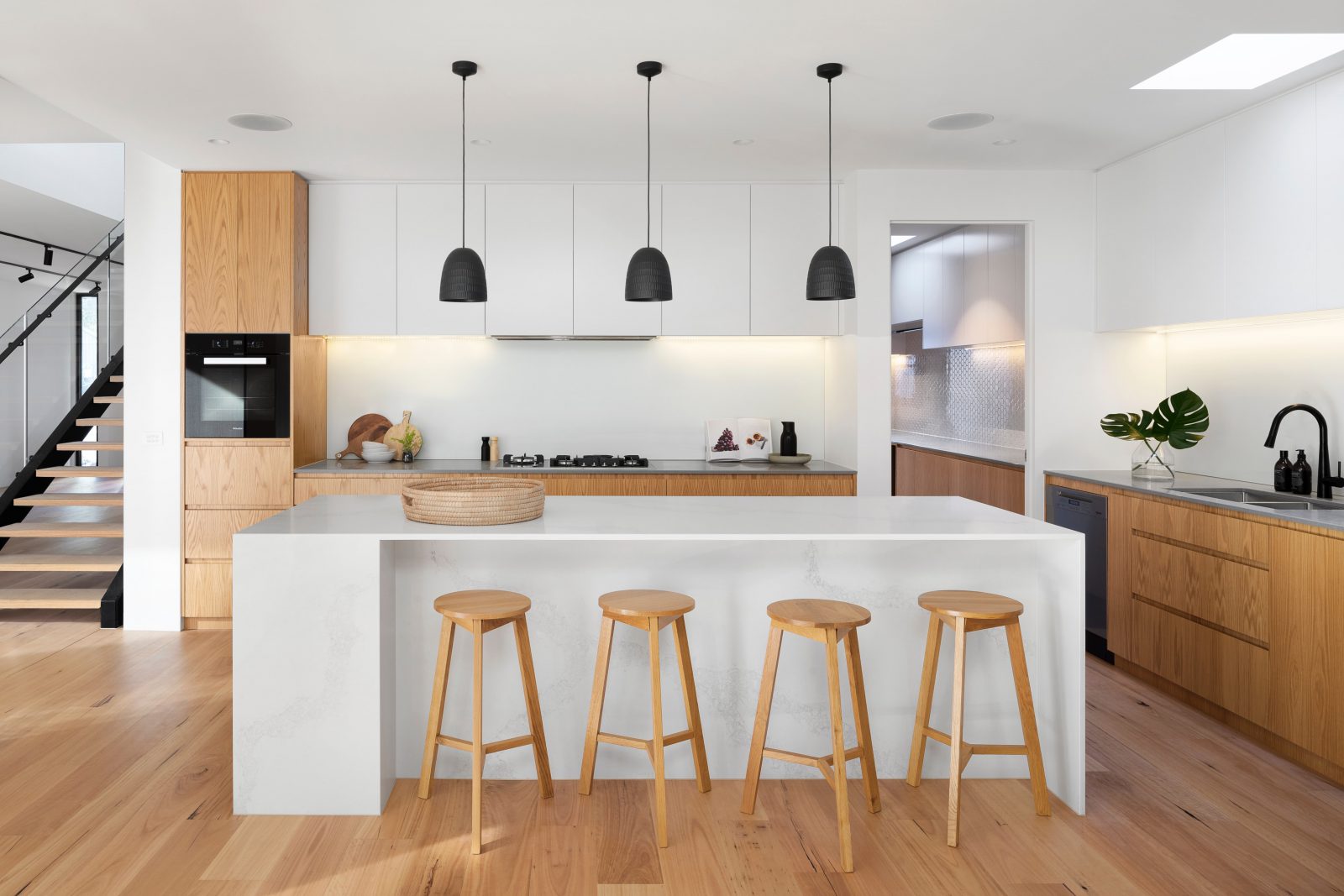 minimalistyczna biała kuchnia z czarnymi lampami