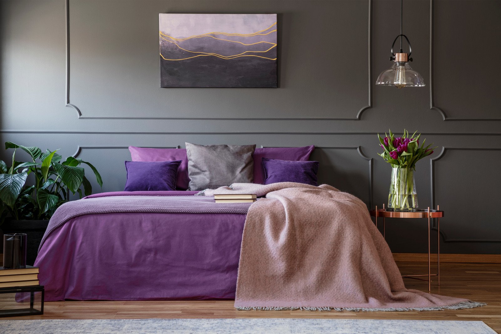 duże łóżko, fioletowe tekstylia, ciemne ściany
