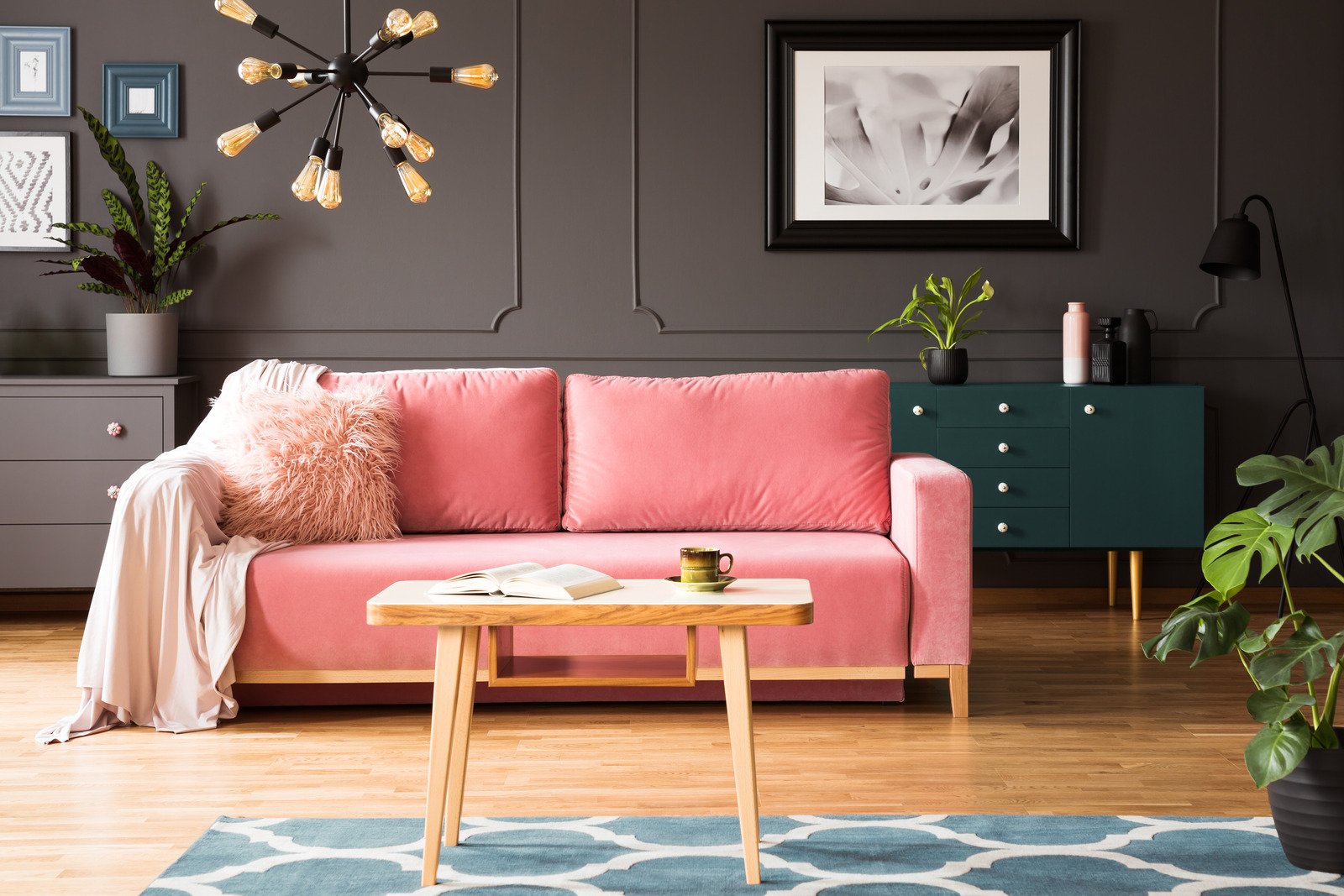 różowa sofa, drewniana podłoga, ciemne ściany