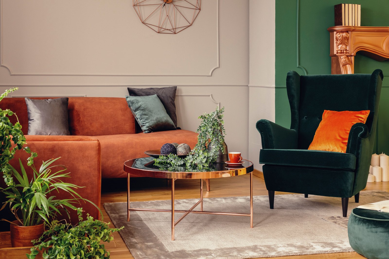zielona ściana, sztukaterie, pomarańczowa sofa